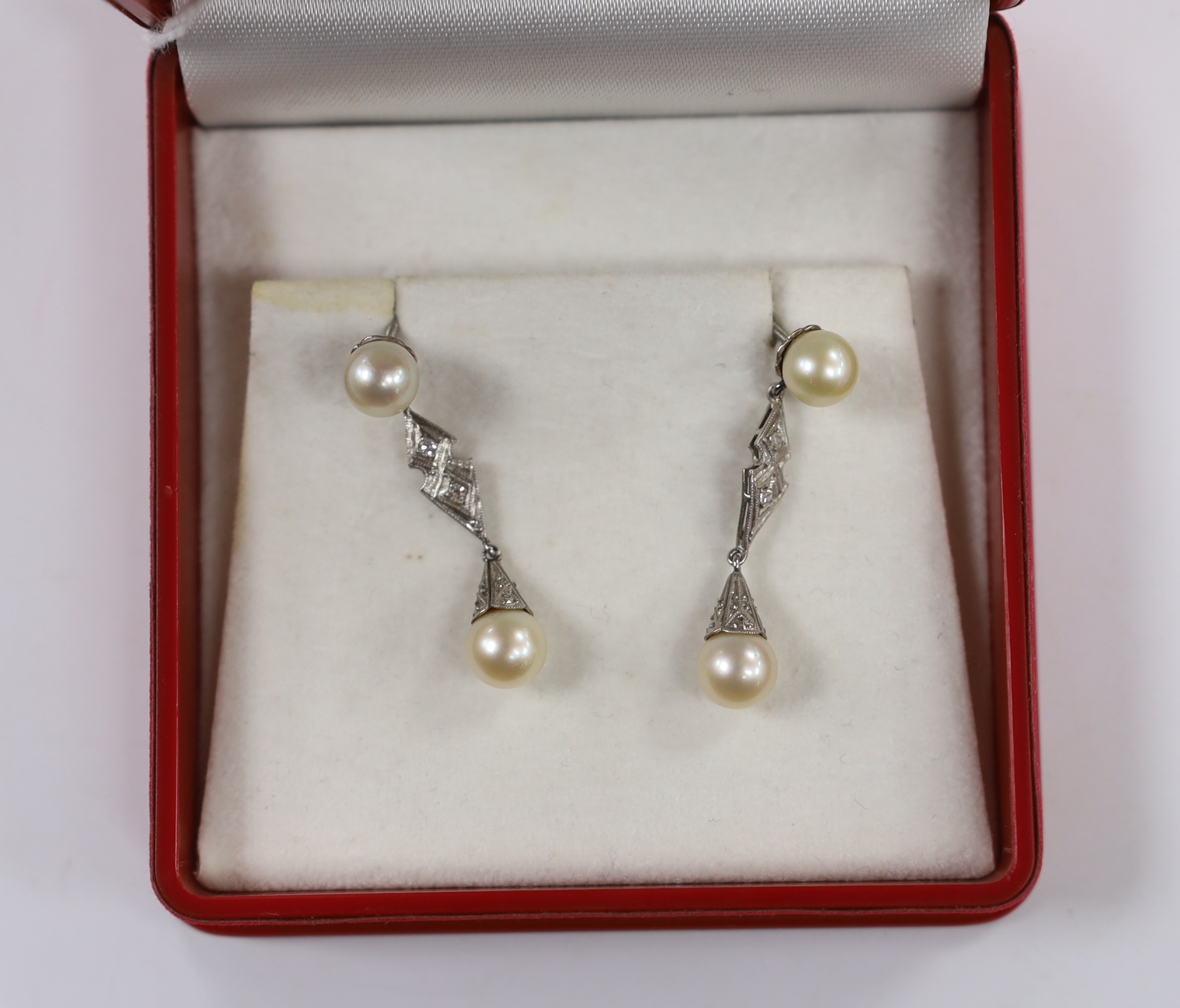 A pair of white metal, two stone cultured pearl and two stone diamond chip set drop earrings, 37mm, gross weight 6.1 grams.